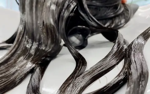 Glossy dark hair coated in a conditioning treatment